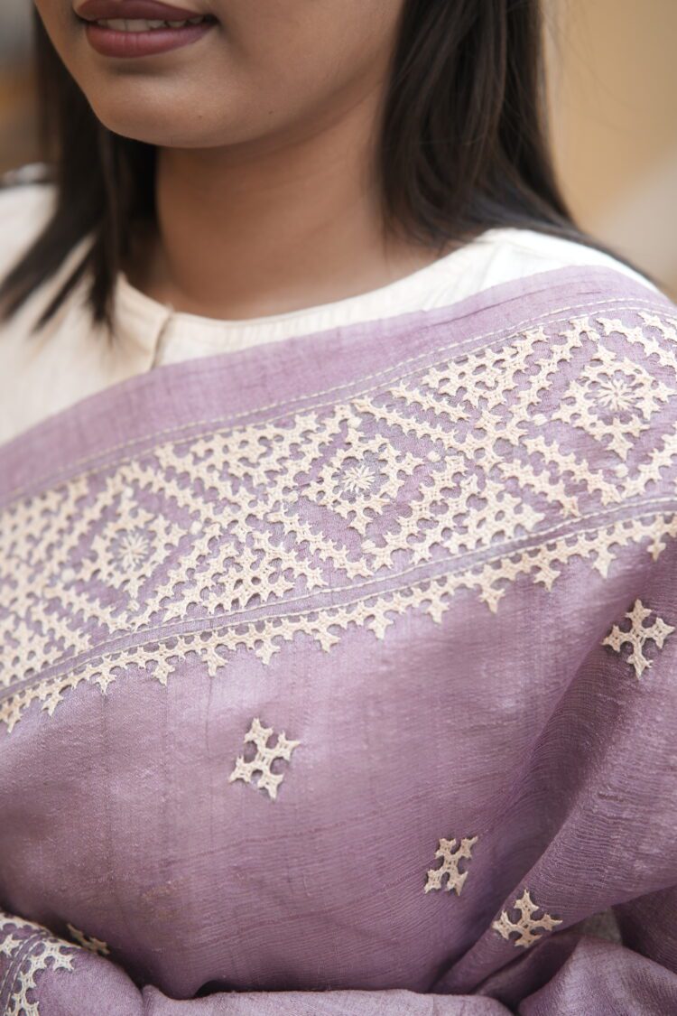 Mauve Tussar silk saree featuring intricate beige Gujarati hand embroidery throughout the body and border.