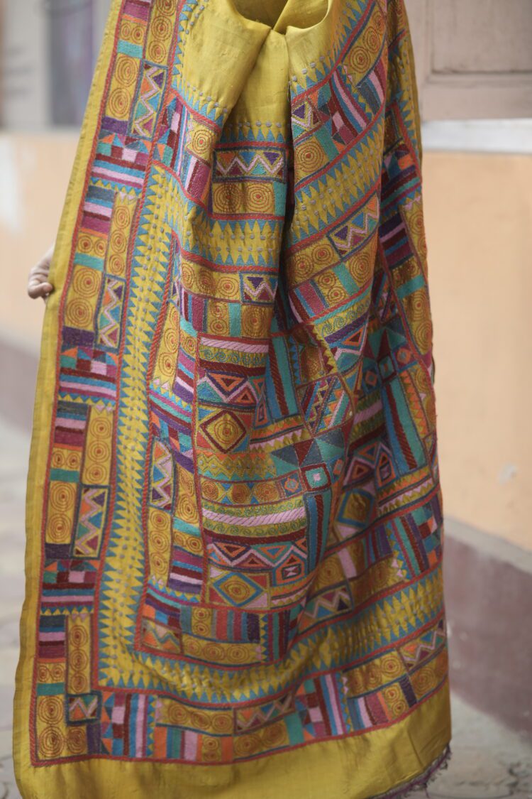 Close-up of multicolour geometric Kantha hand embroidery on chrome yellow saree