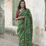 Green silk saree featuring heavy Kantha hand embroidery diagonally from pallu to pleats with rich handcrafted detailing.