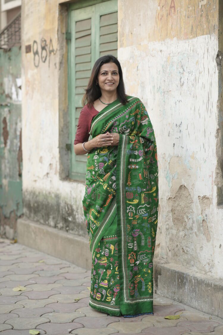 Green silk saree featuring heavy Kantha hand embroidery diagonally from pallu to pleats with rich handcrafted detailing.