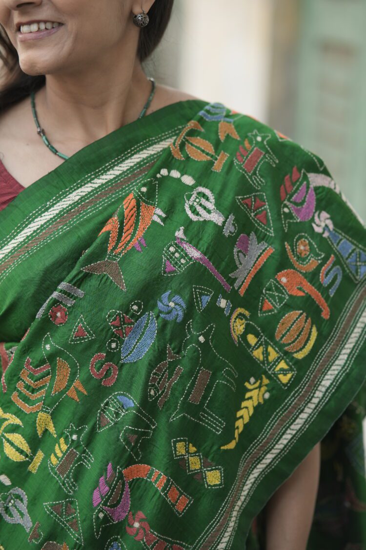 Green silk saree featuring heavy Kantha hand embroidery diagonally from pallu to pleats with rich handcrafted detailing.
